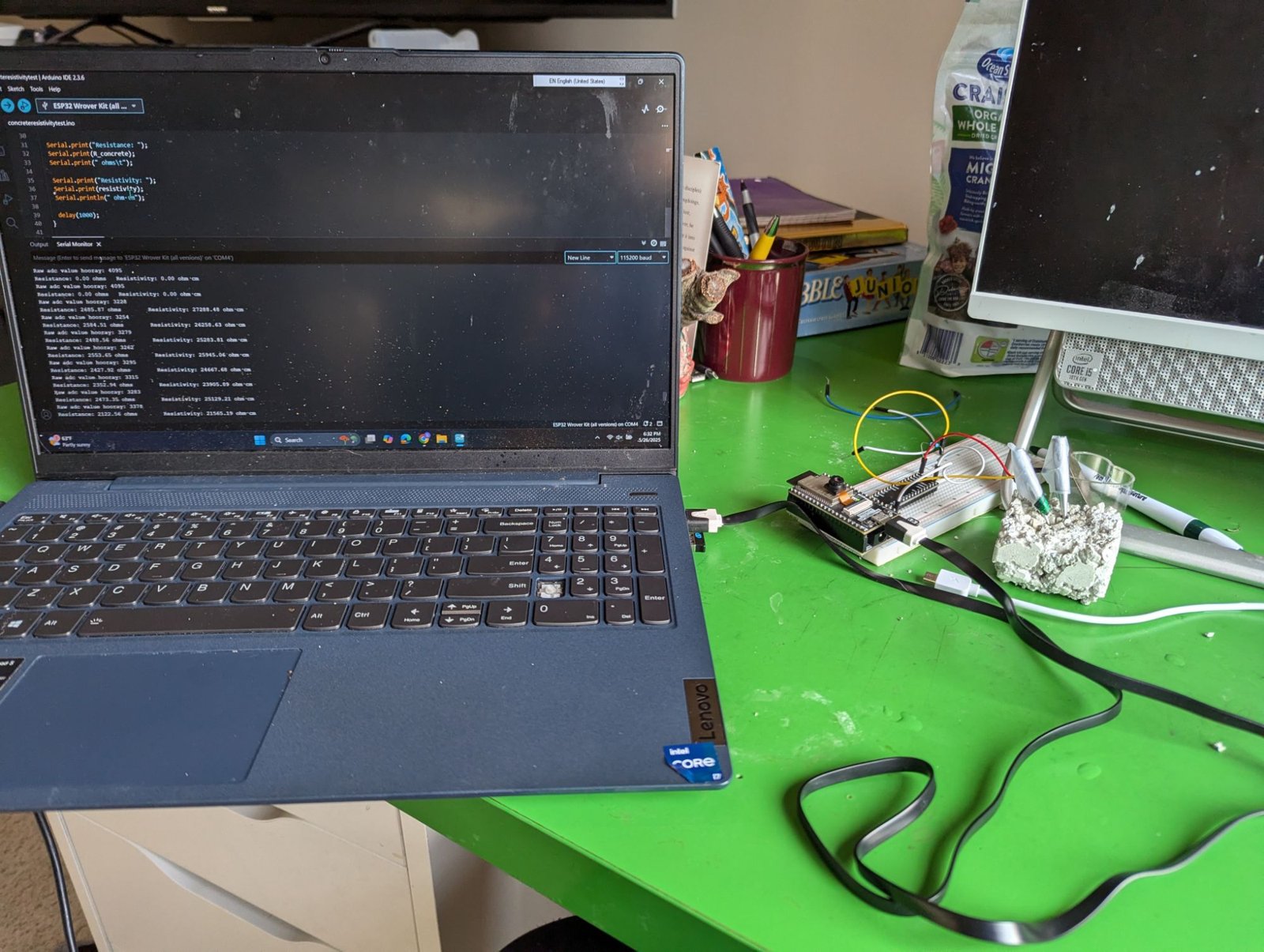 Custom electrical-resistivity circuit on a breadboard testing a cement sample, with readings on a laptop