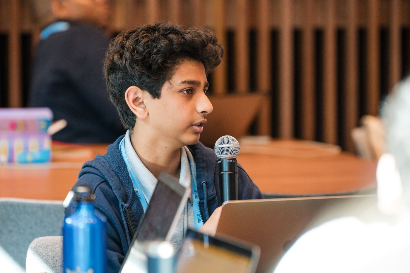 Smaran speaking into a microphone during a Rise Global Summit session