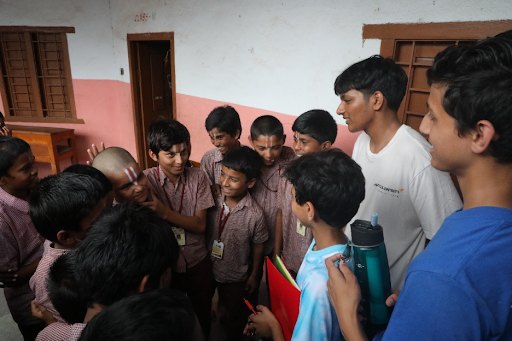Smaran and other volunteers talking with a group of students